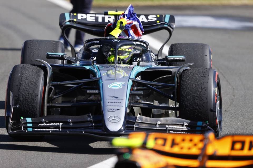 Lewis Hamilton celebrates with a British flag after winning at Silverstone in 2024.