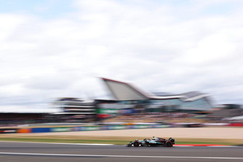 Mercedes Formula 1 car at speed in front of the Silverstone Wing.