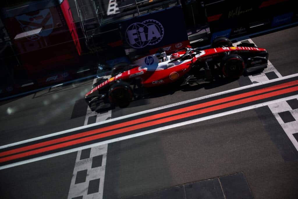 Ferrari Formula 1 car crossing the start‑finish area at the Melbourne Grand Prix circuit.