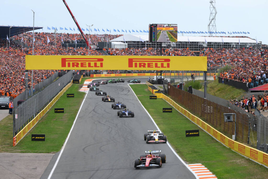 cars launching down the main straight at the Dutch Grand Prix with the Pirelli banner overhead