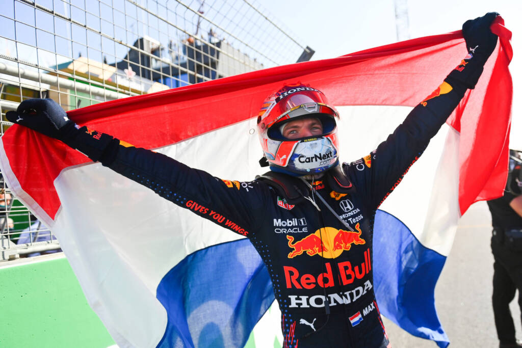 Red Bull driver Max Verstappen celebrates at Zandvoort while holding a Dutch flag after the race