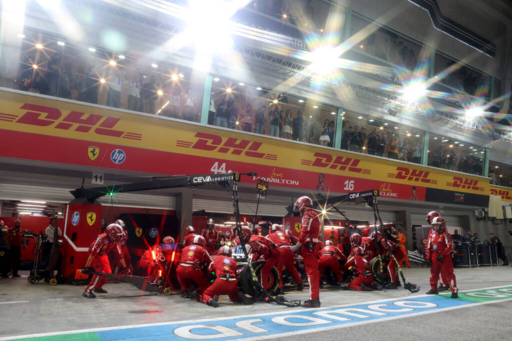 Scuderia Ferrari pit crew performing a pit stop under bright floodlights during the Singapore Grand Prix night race.
